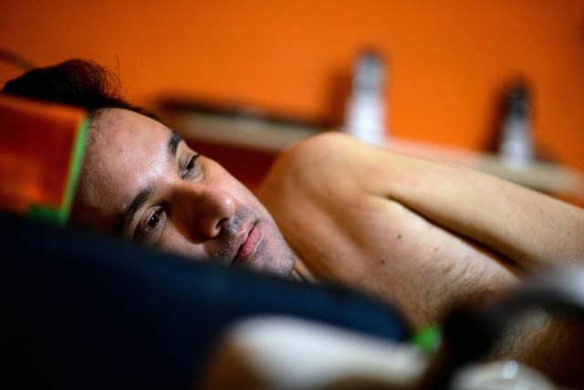 Marco Guillen, a 45-year-old quadriplegic, rests after an interview with AFP at his house in Barquisimeto, Lara state, Venezuela on October 23, 2017. Marco Guillen became quadriplegic in an accident twelve years ago, amid Venezuela's deep economical crisis he desperately asks President Maduro's government to help him to live with dignity, meeting his medical necessities otherwise he pleads for euthanasia. / AFP PHOTO / FEDERICO PARRA / TO GO WITH AFP STORY by MARGIONI BERMUDEZ