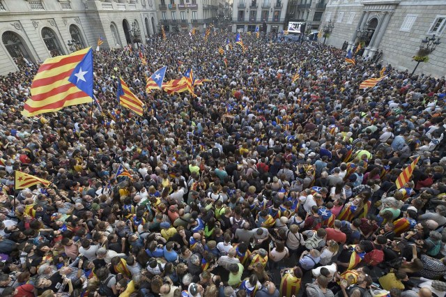 People gather to celebrate at the Sant Jaume square in Barcelona on October 27, 2017.  Catalonia's parliament voted to declare independence from Spain and proclaim a republic, just as Madrid is poised to impose direct rule on the region to stop it in its tracks. A motion declaring independence was approved with 70 votes in favour, 10 against and two abstentions, with Catalan opposition MPs walking out of the 135-seat chamber before the vote in protest at a declaration unlikely to be given official recognition.  / AFP PHOTO / LLUIS GENE
