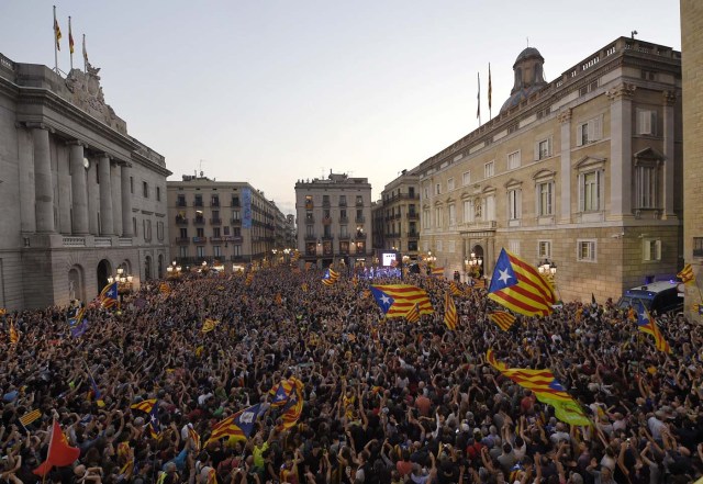 People gather to celebrate the proclamation of a Catalan republic at the Sant Jaume square in Barcelona on October 27, 2017.  Catalonia's parliament voted to declare independence from Spain and proclaim a republic, just as Madrid is poised to impose direct rule on the region to stop it in its tracks. A motion declaring independence was approved with 70 votes in favour, 10 against and two abstentions, with Catalan opposition MPs walking out of the 135-seat chamber before the vote in protest at a declaration unlikely to be given official recognition.  / AFP PHOTO / LLUIS GENE