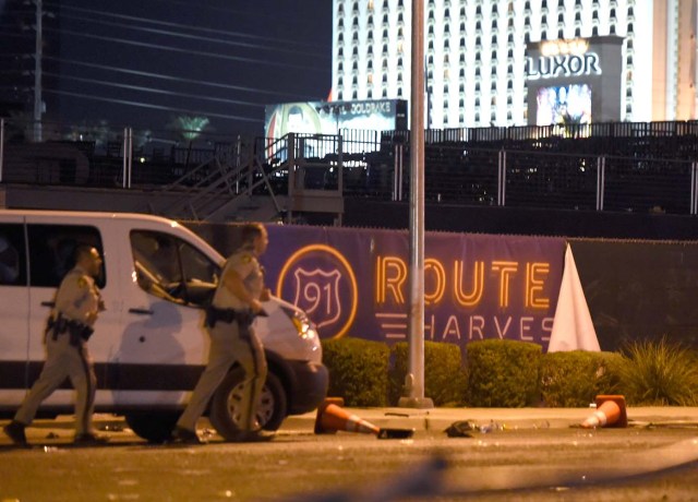 LAS VEGAS, NV - OCTOBER 02: Las Vegas police run by a banner on the fence at the Route 91 Harvest country music festival grounds after a active shooter was reported on October 2, 2017 in Las Vegas, Nevada. A gunman has opened fire on a music festival in Las Vegas, leaving at least 20 people dead and more than 100 injured. Police have confirmed that one suspect has been shot. The investigation is ongoing. David Becker/Getty Images/AFP