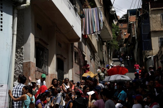 Los ciudadanos venezolanos esperan en fila en una mesa de votación durante una elección nacional para nuevos gobernadores en Caracas, Venezuela, el 15 de octubre de 2017. REUTERS / Ricardo Moraes