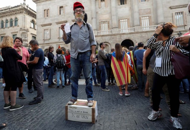 A man stages a performance in Plaza Sant Jaume after a protest called by pro-independence groups for citizens to gather at noon in front of city halls throughout Catalonia, in Barcelona, Spain October 2, 2017. REUTERS/Yves Herman