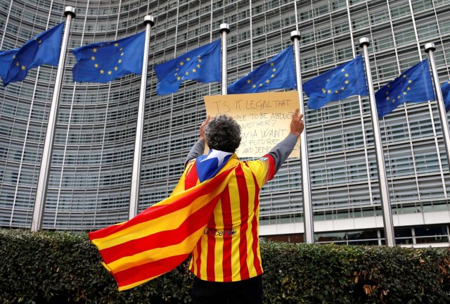 Catalan Raimon Castellvi wears a flag with an Estelada (Catalan separatist flag) as he protests outside the European Commission in Brussels after Sunday's independence referendum in Catalonia, Belgium, October 2, 2017. REUTERS/Francois Lenoir