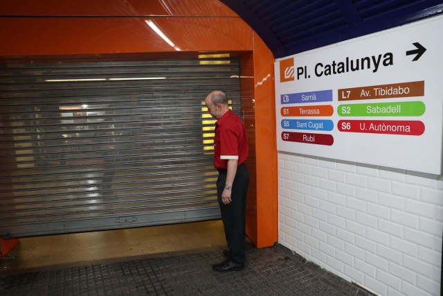 A worker closes an entrance gate to Catalunya Square subway station during a partial regional strike called by pro-independence parties and unions in Barcelona, Spain, October 3, 2017. REUTERS/Susana Vera