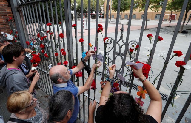 People place flowers on the gate of the Ramon Llull high school where Spanish police clashed with voters during the banned referendum in Barcelona, Spain October 3, 2017. REUTERS/Yves Herman