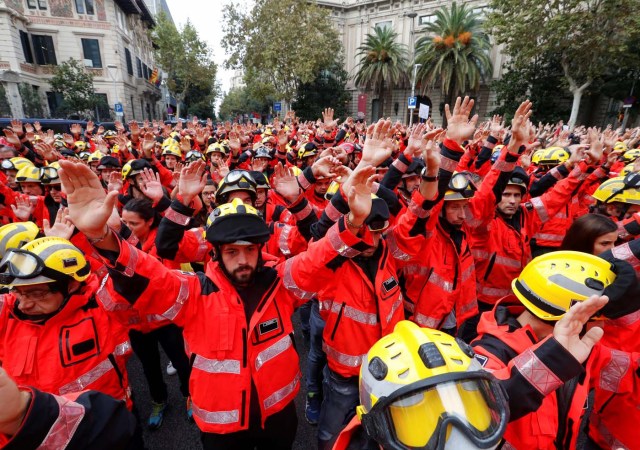 Firefighters hold up their hands during a demonstration called to protest against police actions during the banned independence referendum in Barcelona, Spain October 3, 2017. REUTERS/Yves Herman