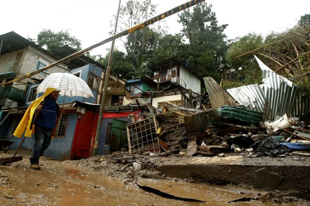 Un hombre camina cerca de casas dañadas por las fuertes lluvias que dejó la tormenta tropical Nate, en San José de Costa Rica. 5 de octubre 2017. REUTERS/Juan Carlos Ulate