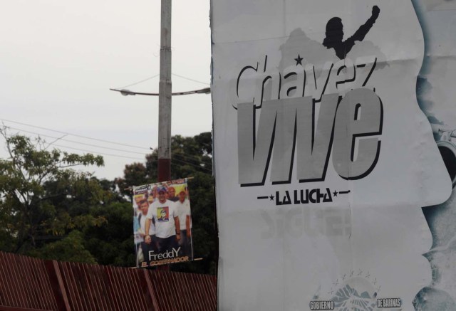 A banner of the opposition Democratic Unity coalition candidate for Barinas state Freddy Superlano (L) is pictured next to a banner in which reads "Chavez lives"in Barinas, Venezuela, October 2, 2017. Picture taken on October 2, 2017. REUTERS/Ricardo Moraes