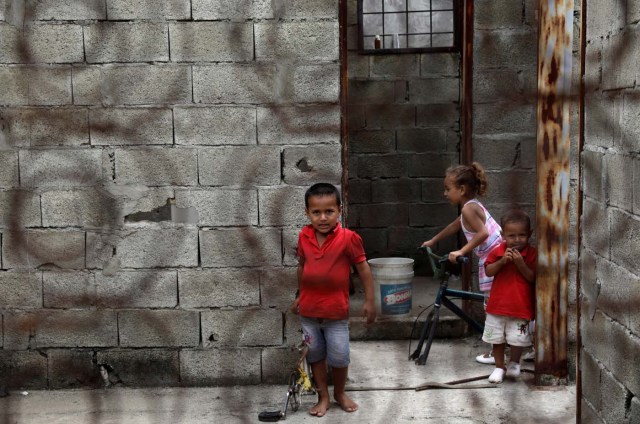 Children are pictured through an improvised door as they play around while the opposition Democratic Unity coalition candidate for Barinas state Freddy Superlano campaigns on the outskirts of Barinas, Venezuela, October 3, 2017. Picture taken on October 3, 2017. REUTERS/Ricardo Moraes