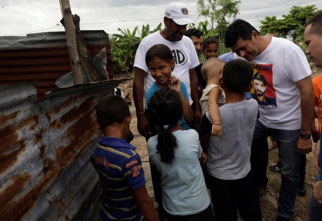 The opposition Democratic Unity coalition candidate for Barinas state Freddy Superlano (C) talks with residents of a slum while campaigning on the outskirts of Barinas, Venezuela, October 3, 2017. Picture taken on October 3, 2017. REUTERS/Ricardo Moraes