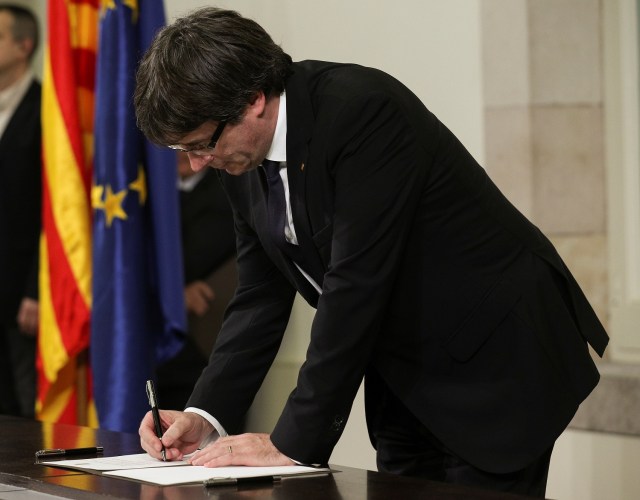 El presidente catalán Carles Puigdemont firma la declaración de independencia de la región en Barcelona. 10 de octubre de 2017. REUTERS/Albert Gea