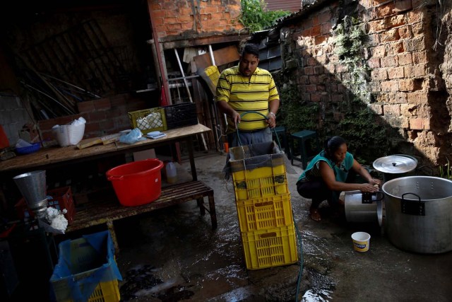 Medical equipment repairman Leandro Colmenares (C) makes corn dough at the backyard of his house in Caracas, Venezuela October 3, 2017. Picture taken October 3, 2017. REUTERS/Carlos Garcia Rawlins