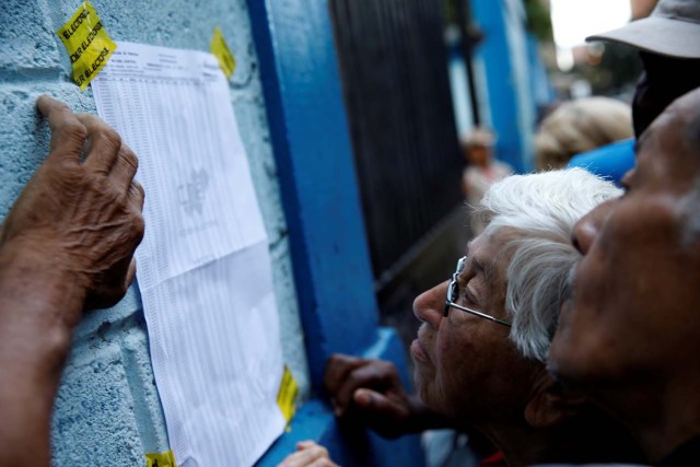 Venezuela's citizens check a list in a polling station during a nationwide election for new governors in Caracas, Venezuela, October 15, 2017. REUTERS/Carlos Garcia Rawlins