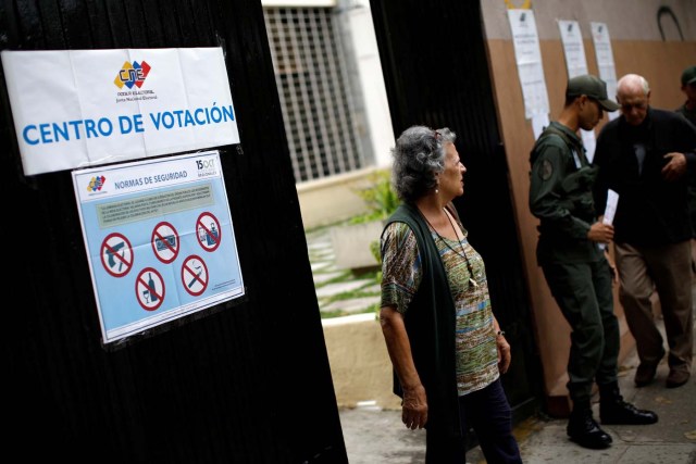 A woman leaves a polling station after casting her vote during a nationwide election for new governors in Caracas, Venezuela, October 15, 2017. REUTERS/Carlos Garcia Rawlins