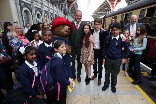 Actor Hugh Bonneville stands next to a costumed figure of Paddington bear as he waits for Britain's Prince William, Catherine, The Duchess of Cambridge and Prince Harry to arrive at the Charities Forum at Paddington Station in London, October 16, 2017. REUTERS/Jonathan Brady/Pool