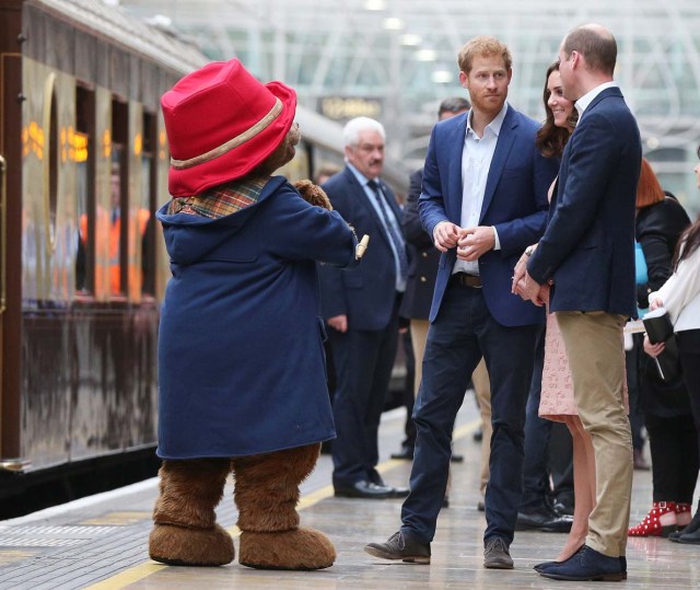 Britain's Catherine the Duchess of Cambridge, Prince William and Prince Harry stand next to a costumed figure of Paddington bear on platform 1 at Paddington Station, as they attend the Charities Forum in London, October 16, 2017. REUTERS/Jonathan Brady/Pool