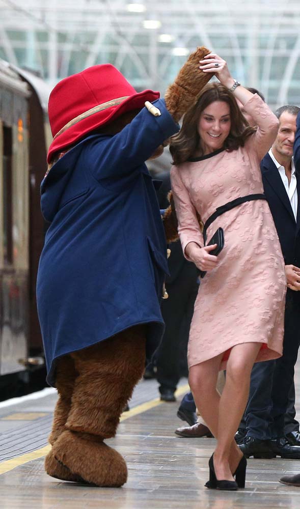 Britain's Catherine the Duchess of Cambridge dances with a costumed figure of Paddington bear on platform 1 at Paddington Station, as they attend the Charities Forum in London, October 16, 2017. REUTERS/Jonathan Brady/Pool