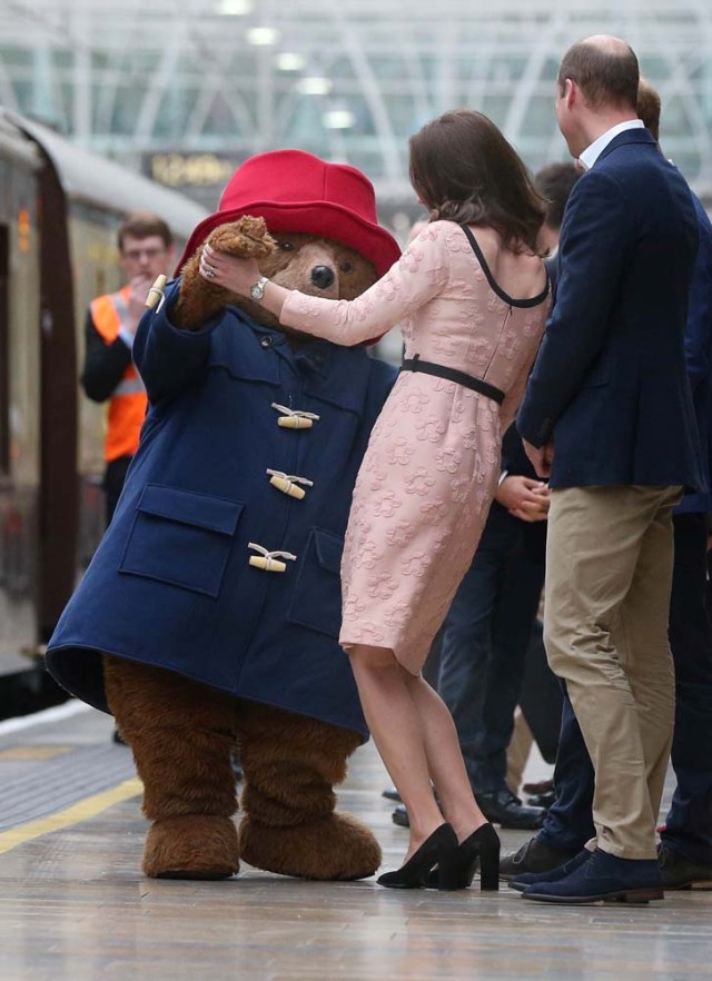Britain's Prince William watches as his wife Catherine the Duchess of Cambridge dances with a costumed figure of Paddington bear on platform 1 at Paddington Station, as they attend the Charities Forum in London, October 16, 2017. REUTERS/Jonathan Brady/Pool