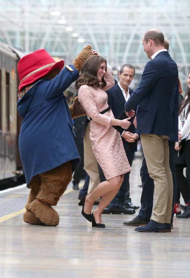 Britain's Prince William watches as his wife Catherine the Duchess of Cambridge dances with a costumed figure of Paddington bear on platform 1 at Paddington Station, as they attend the Charities Forum in London, October 16, 2017. REUTERS/Jonathan Brady/Pool