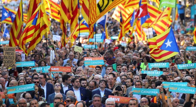 Catalan President Carles Puigdemont (C) and other Catalan regional government members attend a demonstration organised by Catalan pro-independence movements ANC (Catalan National Assembly) and Omnium Cutural, following the imprisonment of their two leaders Jordi Sanchez and Jordi Cuixart, in Barcelona, Spain, October 21, 2017. REUTERS/Ivan Alvarado