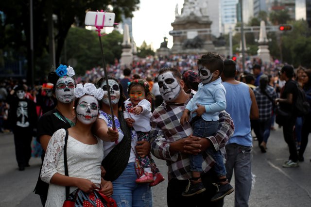 A family dressed up as "Catrin and Catrina", a Mexican character also known as "The Elegant Death", take a selfie during the Catrinas parade in Mexico City, Mexico October 22, 2017. REUTERS/Carlos Jasso