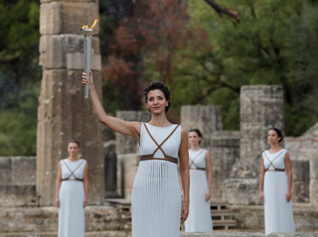 Olympics - Lighting Ceremony of the Olympic Flame Pyeongchang 2018 - Ancient Olympia, Olympia, Greece - October 24, 2017 Greek actress Katerina Lehou, playing the role of High Priestess and actresses with the flame during the Olympic flame lighting ceremony for the Pyeongchang 2018 Winter Olympics REUTERS/Alkis Konstantinidis