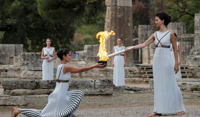 Olympics - Lighting Ceremony of the Olympic Flame Pyeongchang 2018 - Ancient Olympia, Olympia, Greece - October 24, 2017 Greek actress Katerina Lehou, playing the role of High Priestess with the flame on the torch during the Olympic flame lighting ceremony for the Pyeongchang 2018 Winter Olympics REUTERS/Alkis Konstantinidis