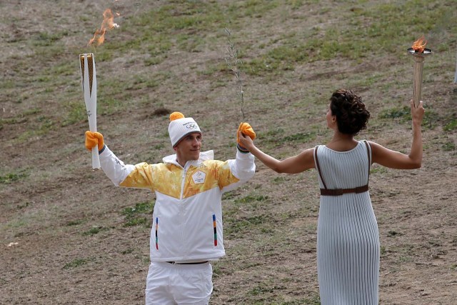 Olympics - Lighting Ceremony of the Olympic Flame Pyeongchang 2018 - Ancient Olympia, Olympia, Greece - October 24, 2017 Greek actress Katerina Lehou, playing the role of High Priestess gives an olive branch to Greek cross country skiing athlete Apostolos Aggelis during the Olympic flame lighting ceremony for the Pyeongchang 2018 Winter Olympics REUTERS/Costas Baltas