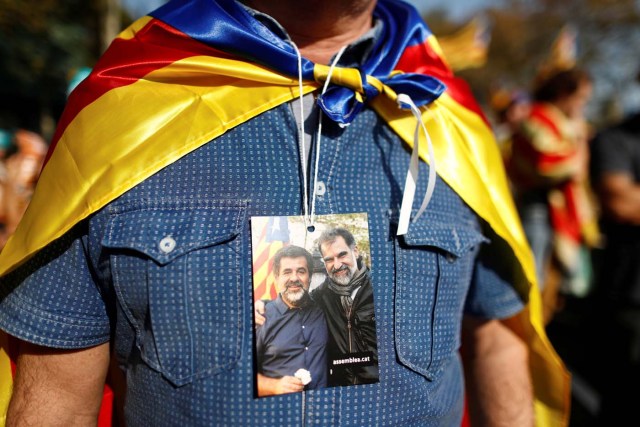 A demonstrators wears a photograph of the jailed leaders of Catalan pro-independence movements ANC (Catalan National Assembly) and Omnium Cutural, Jordi Sanchez and Jordi Cuixart, near the Catalan regional parliament in Barcelona, Spain, October 27, 2017. REUTERS/Juan Medina
