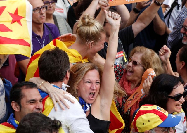 People react as they watch on giant screens a plenary session outside the Catalan regional parliament in Barcelona, Spain, October 27, 2017. REUTERS/Yves Herman