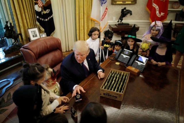 U.S. President Donald Trump gives out Halloween treats to children of members of press and White House staff at the Oval Office of the White House in Washington, U.S., October 27, 2017. REUTERS/Carlos Barria