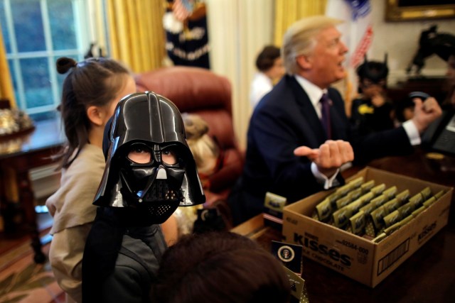 REFILE - CORRECTING GRAMMAR U.S. President Donald Trump gives out Halloween treats to children of members of press and White House staff in the Oval Office of the White House in Washington, U.S., October 27, 2017. REUTERS/Carlos Barria