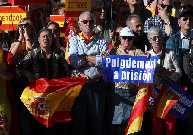 Manifestantes pro unidad con pancartas que piden el encarcelamiento del presidente catalán despedido, Carles Puigdemont, se reúnen en Madrid, España, el 28 de octubre de 2017. REUTERS / Susana Vera