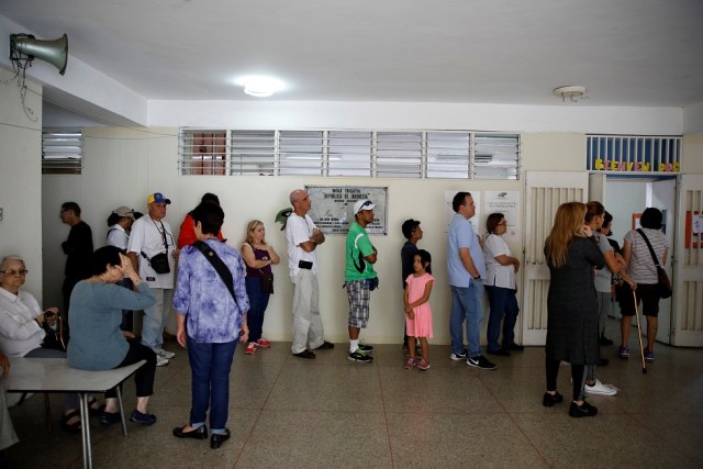 La gente espera para emitir su voto en una mesa de votación durante una elección nacional para nuevos gobernadores en Caracas, Venezuela, el 15 de octubre de 2017. REUTERS / Carlos Garcia Rawlins