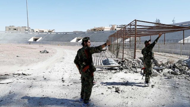 Combatientes de las SDF se toman selfis junto al estadio reconquistado en Raqa. 18 de octubre de 2017.