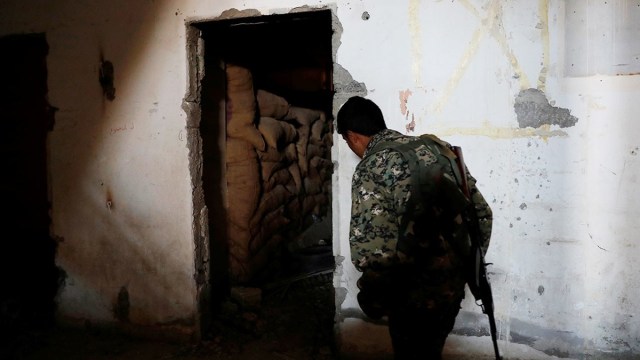 Un combatiente de las Fuerzas Democráticas Sirias accede al subsuelo del estadio de Raqa desde donde operaban los yihadistas. 18 de octubre de 2017.