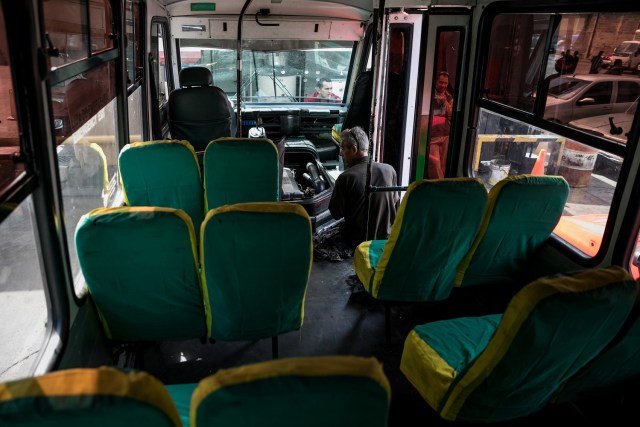 Fotografías del 10 de octubre del 2017, de un mecánico que trabaja en un bus de transporte público, en la ciudad de Caracas (Venezuela). Los altos costos de mantenimiento, la disminución de importación de repuestos, una galopante inflación y la escasez de efectivo tienen al sistema de transporte de Venezuela en jaque, mientras la población padece los efectos de esta crisis con un pasaje inestable y largos tiempos de espera para trasladarse. EFE/MIGUEL GUTIÉRREZ
