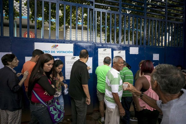 GRA120. CARACAS (VENEZUELA), 15/10/2017 - Varias personas asisten a un centro de votación hoy, 15 de octubre de 2017, en Caracas (Venezuela). Los centros de votación en Venezuela comenzaron hoy a abrir sus puertas a las seis de la mañana hora local (10.00 GMT), como estaba previsto, para atender a los ciudadanos que están llamados a participar en la elección de los 23 gobernadores del país caribeño. EFE/Miguel Gutiérrez