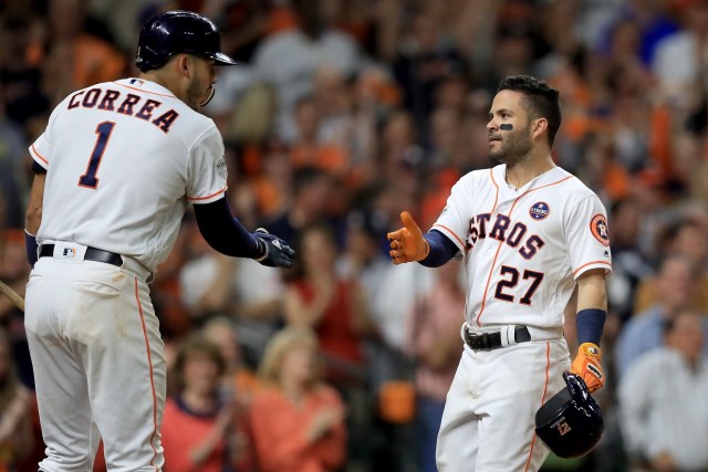 HOUSTON, TX - OCTOBER 20: Jose Altuve #27 of the Houston Astros celebrates with teammate Carlos Correa #1 after hitting a solo home run against David Robertson #30 of the New York Yankees during the eighth inning in Game Six of the American League Championship Series at Minute Maid Park on October 20, 2017 in Houston, Texas. Ronald Martinez/Getty Images/AFP