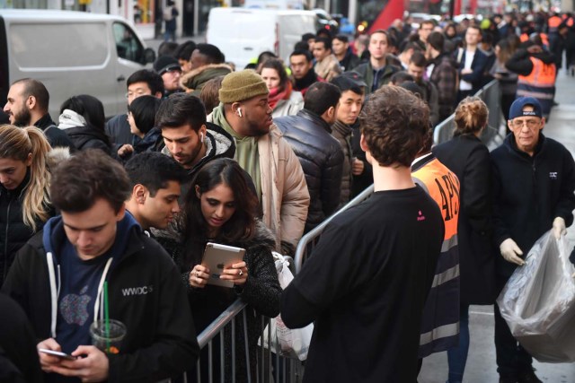 People queue outside Apple's Regent Street store in central London on November 3, 2017 waiting for the store to open on the say of the launch of the Apple iPhone X. Apple's flagship iPhone X hit stores on November 3, as the world's most valuable company predicted bumper sales despite the handset's eye-watering price tag and celebrated a surge in profits. The device features facial recognition, cordless charging and an edge-to-edge screen made of organic light-emitting diodes used in high-end televisions. It marks the 10th anniversary of the first iPhone release and is released in about 50 markets around the world. / AFP PHOTO / Chris J Ratcliffe