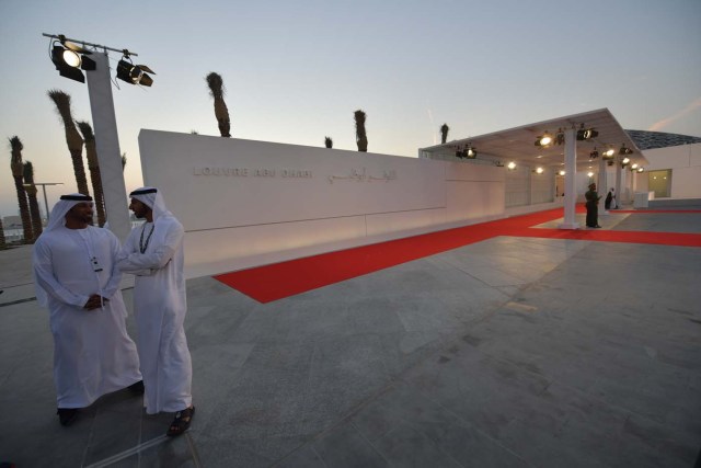 Emirati men stand at the entrance to the Louvre Abu Dhabi prior to the inauguration of the museum on November 8, 2017. More than a decade in the making, the Louvre Abu Dhabi is opening its doors bringing the famed name to the Arab world for the first time. / AFP PHOTO / Giuseppe CACACE
