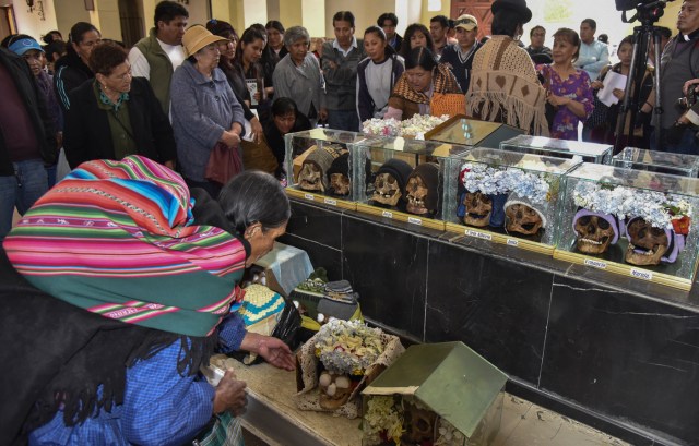 Devotees have their "natitas" (snub-nosed) human skulls blessed at the Central Cemetery's chapel in La Paz, during the annual traditional ritual on November 8, 2017. The "natitas" are meant to protect their owners, who keep them at home all year long and bring them to the cemetery chapels every November 8 to perform rituals which end up in a traditional party. / AFP PHOTO / Aizar RALDES