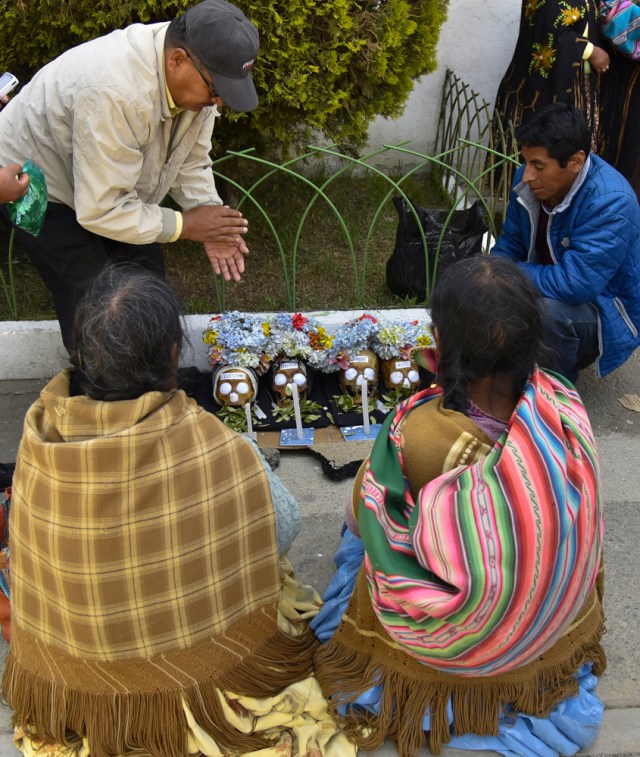 Aymara women pray next to their "natitas" (snub-nosed) human skulls during the annual traditional ritual at the Central Cemetery of La Paz on November 8, 2017. The "natitas" are meant to protect their owners, who keep them at home all year long and bring them to the cemetery chapels every November 8 to perform rituals which end up in a traditional party. / AFP PHOTO / Aizar RALDES