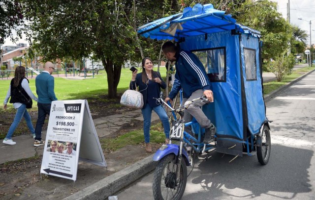 Venezuelan national Gregory Pacheco, 29, works as a "bicitaxi" (pedicab) driver in Bogota, on November 8, 2017. Up to October 2017 there were 470,000 Venezuelans in Colombia, who left their country to escape the hardship and violence of its economic and political crisis. / AFP PHOTO / Raul Arboleda / TO GO WITH AFP STORY by Daniela QUINTERO and Santiago TORRADO