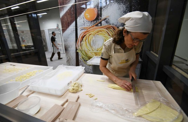 A chef prepares pasta at a stand during a press tour at FICO Eataly World agri-food park in Bologna on November 9, 2017. FICO Eataly World, said to be the world's biggest agri-food park, will open to the public on November 15, 2017. The free entry park, widely described as the Disney World of Italian food, is ten hectares big and will enshrine all the Italian food biodiversity. / AFP PHOTO / Vincenzo PINTO