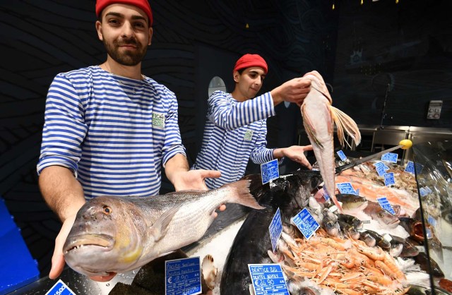 Fishmongers present Mediterranean fish at a stand during a press tour at FICO Eataly World agri-food park in Bologna on November 9, 2017. FICO Eataly World, said to be the world's biggest agri-food park, will open to the public on November 15, 2017. The free entry park, widely described as the Disney World of Italian food, is ten hectares big and will enshrine all the Italian food biodiversity. / AFP PHOTO / Vincenzo PINTO