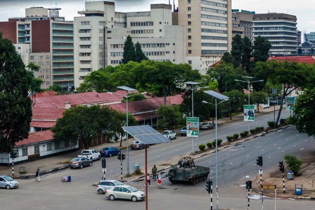 An armoured personnel carrier stations at an intersection as Zimbabwean soldiers regulate traffic in Harare on November 15, 2017. Zimbabwe's military appeared to be in control of the country on November 15 as generals denied staging a coup but used state television to vow to target "criminals" close to President Mugabe. / AFP PHOTO / -