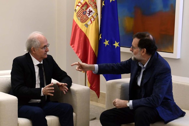 Spanish Prime Minister Mariano Rajoy speaks to former Caracas mayor Antonio Ledezma (L) during a meeting in Madrid on November 18, 2017.  Ledezma arrived from Bogota to Spain after escaping house arrest in the Venezuelan capital, after having been accused of conspiracy against the government. / AFP PHOTO / PIERRE-PHILIPPE MARCOU