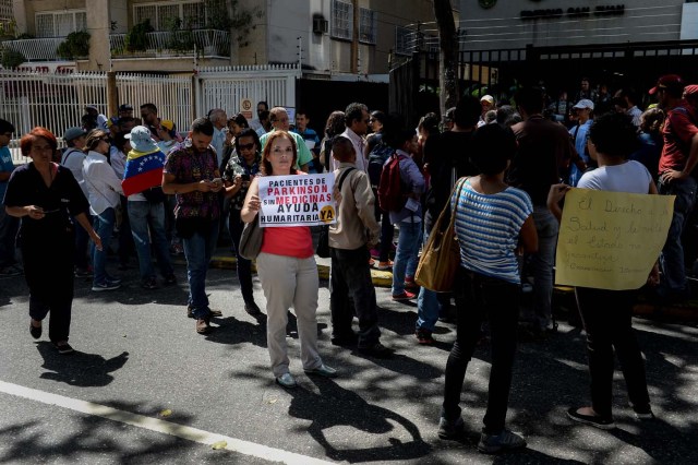 A woman holds a sign during an anti-government demonstration protesting for the shortage of medicines in Caracas on November 20, 2017. / AFP PHOTO / FEDERICO PARRA