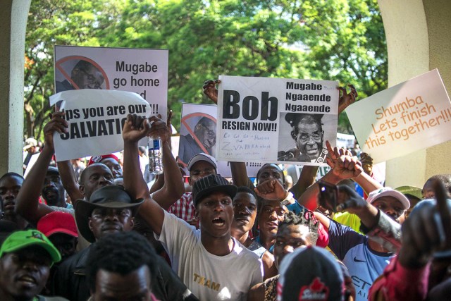 Zimbabweans gather at Unity square opposite to the Parliament to protest against Zimbabwean President Robert Mugabe on November 21, 2017 in Harare. Zimbabwe's parliament prepared to start impeachment proceedings against President Robert Mugabe on November 21, as ousted vice president Emmerson Mnangagwa, who could be the country's next leader, told him to step down. Further street protests have been called in Harare, raising fears that the political turmoil could spill into violence. / AFP PHOTO / MUJAHID SAFODIEN